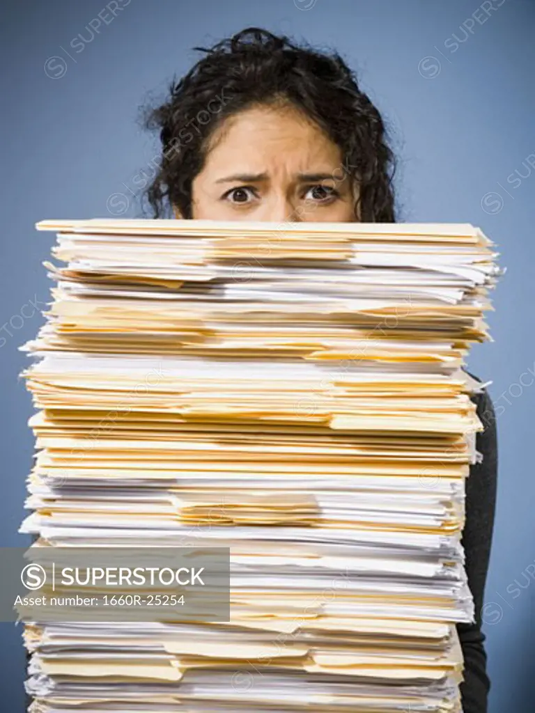 Woman holding stacks of paperwork