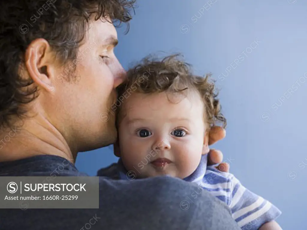 Man kissing baby boy on head