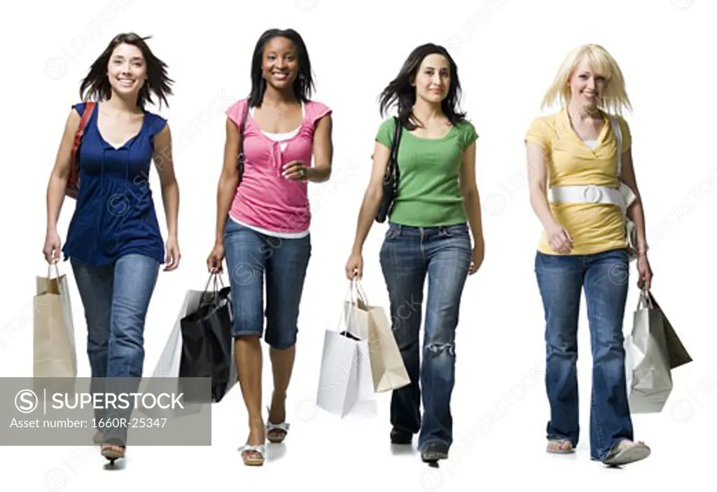 Four women walking and smiling with shopping bags