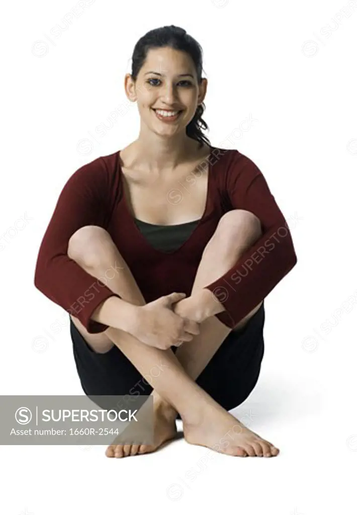 Portrait of a young woman holding her knees