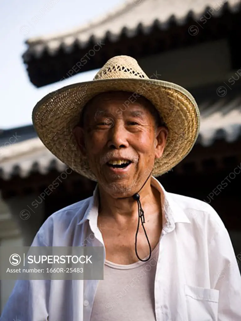 Man with straw hat and cane smiling