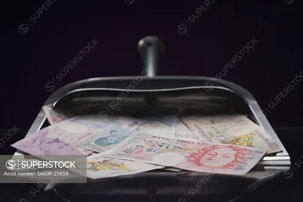 Close-up of British pounds in a dustpan