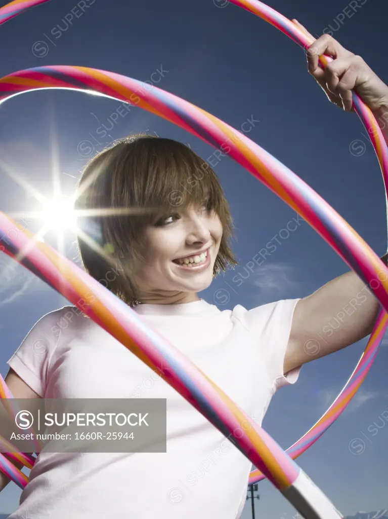 Portrait of a teenage girl holding plastic hoops