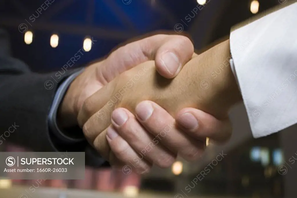 Close-up of a businessman and a businesswoman shaking hands