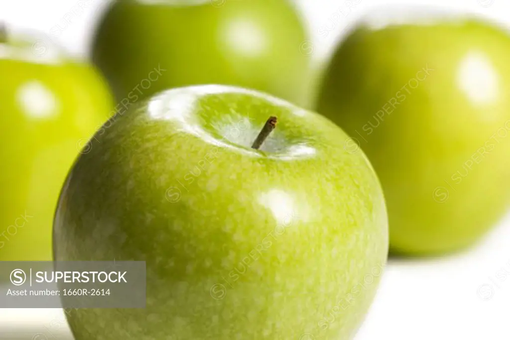 Close-up of four granny smith apples (aphis pomi)