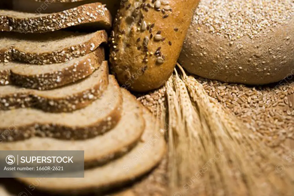 Close-up of wheat stem and slices of brown bread