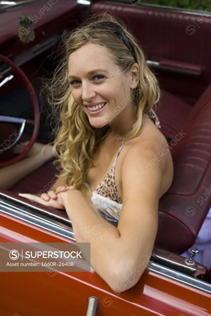 Portrait of a young woman sitting in a car smiling