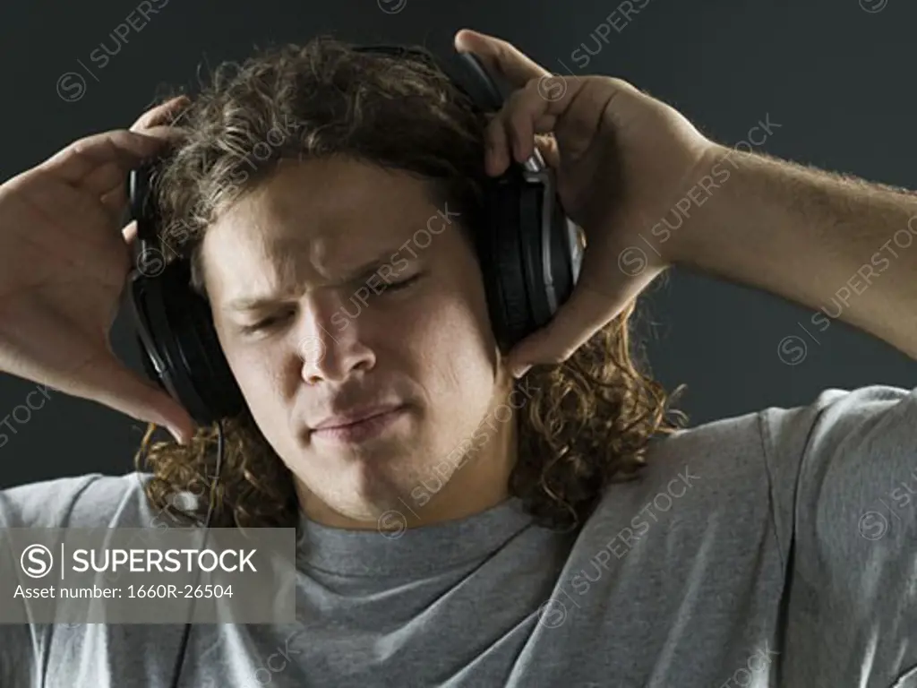 Close-up of a young man listening to the music on headphones