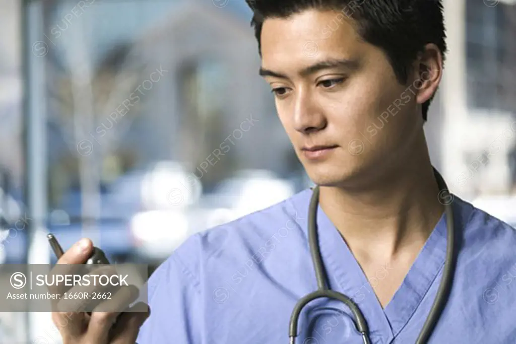 Close-up of a male doctor holding a mobile phone
