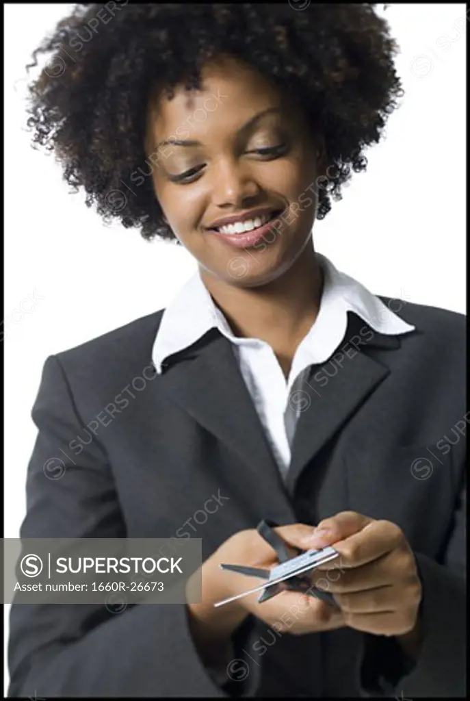 Close-up of a businesswoman cutting a credit card with a pair of scissors