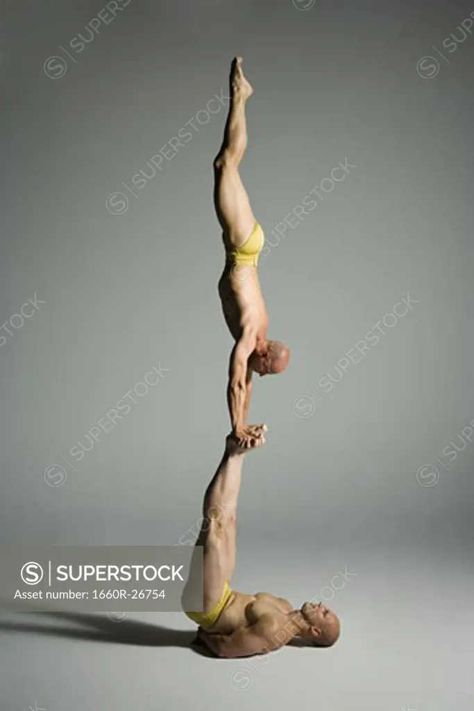 Profile of two male acrobats performing