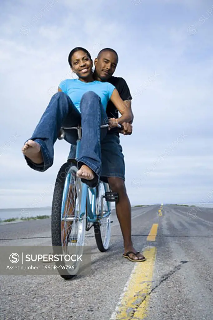 Portrait of a young couple sitting on a bicycle