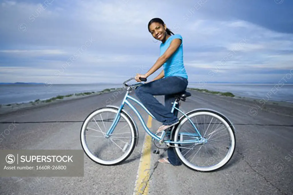 Portrait of a young woman sitting on a bicycle