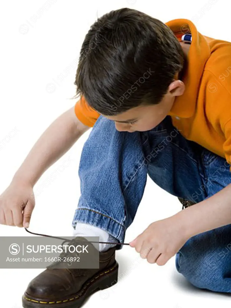 Close-up of a boy tying his shoelace