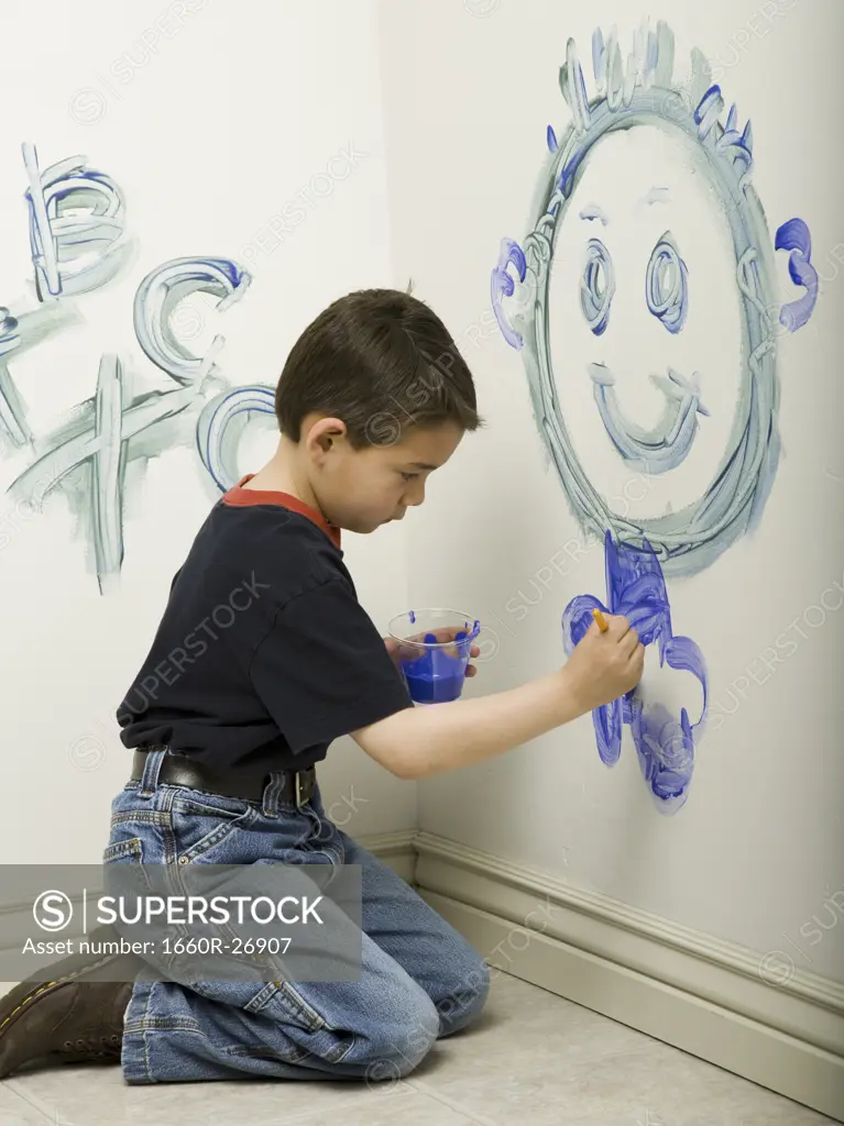 Portrait of a boy painting on a wall