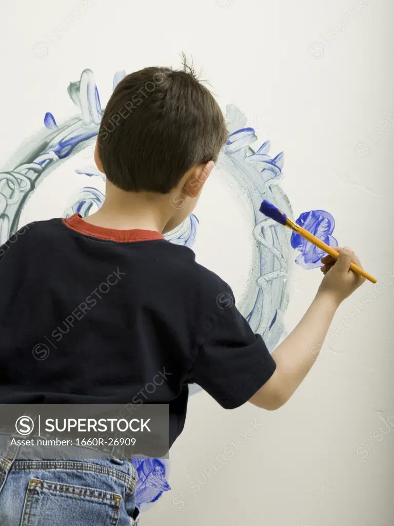 Portrait of a boy painting on a wall