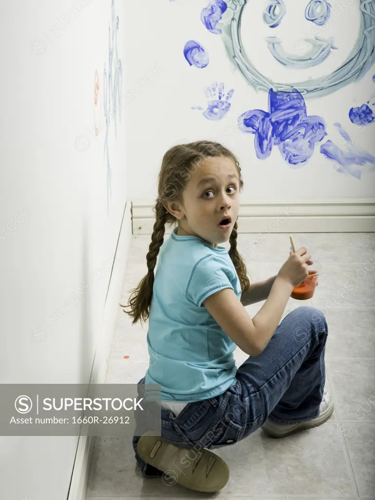 Portrait of a girl painting on a wall