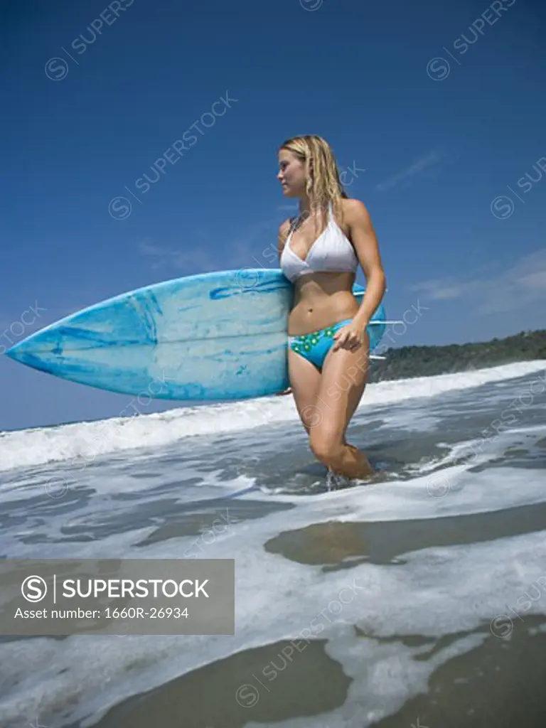 Portrait of a young woman holding a surfboard