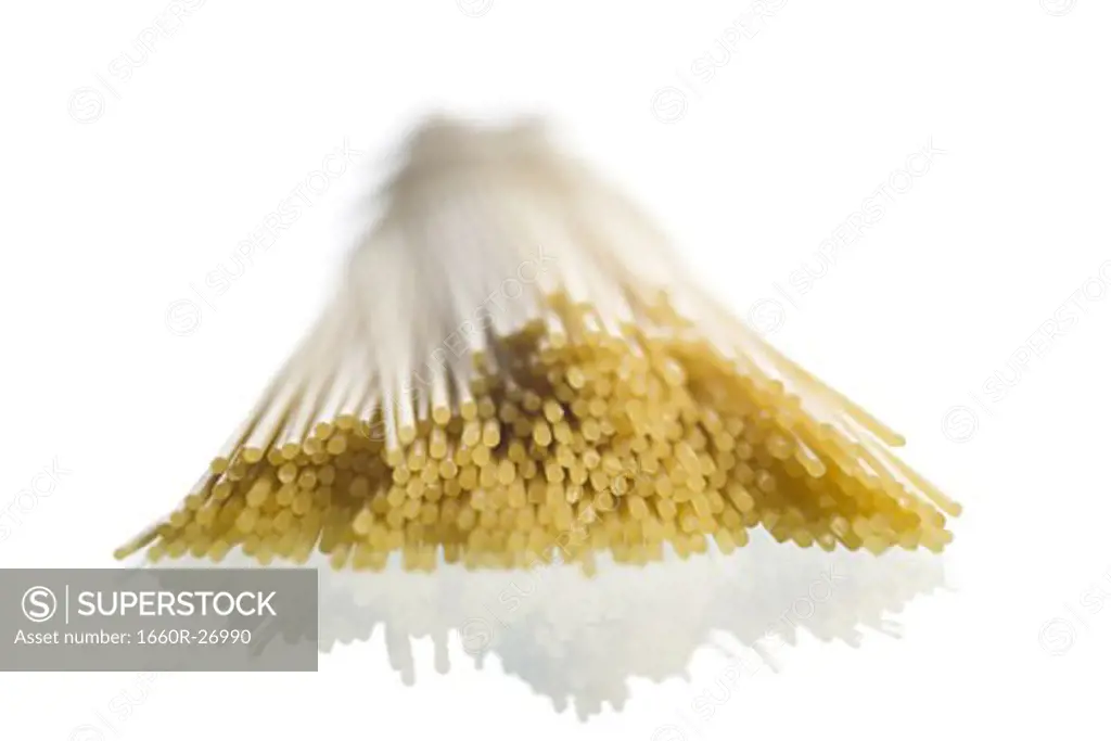 Close-up of uncooked spaghetti against a white background