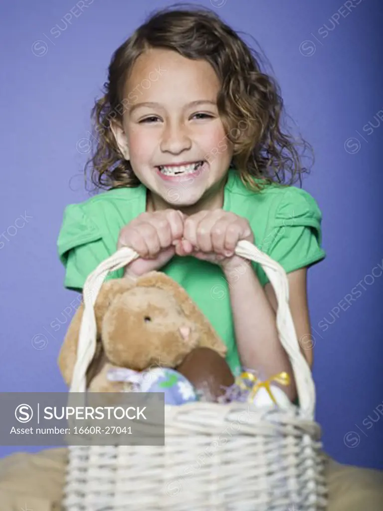 Portrait of a girl holding Easter eggs in a wicker basket