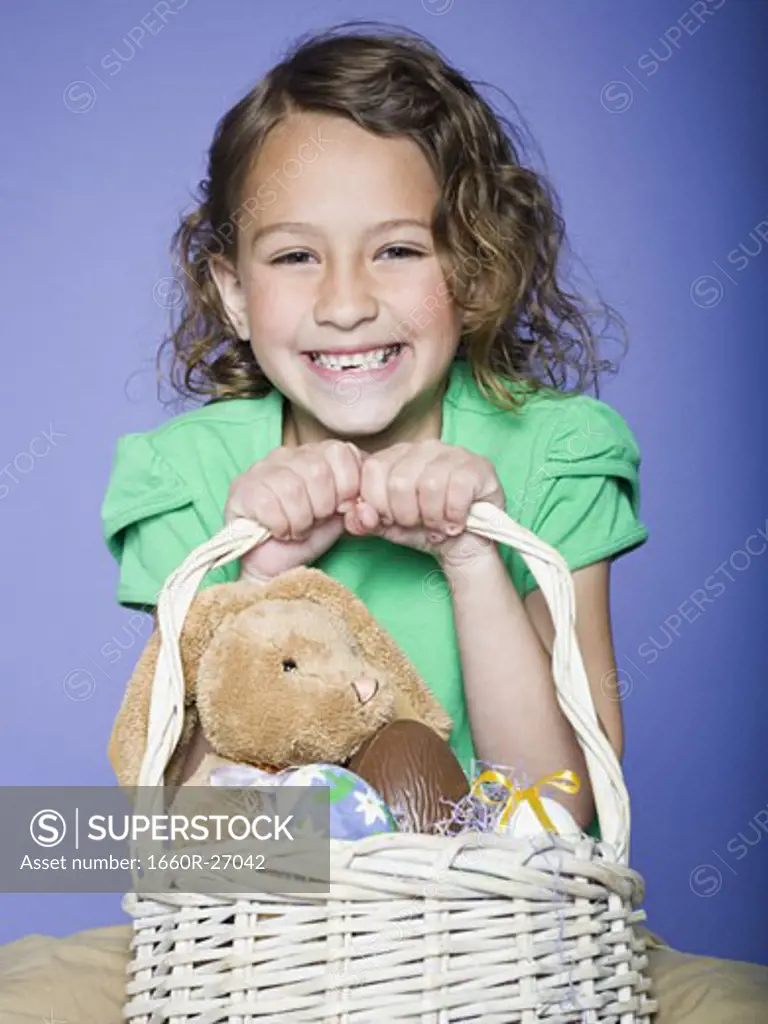 Portrait of a girl holding Easter eggs in a wicker basket