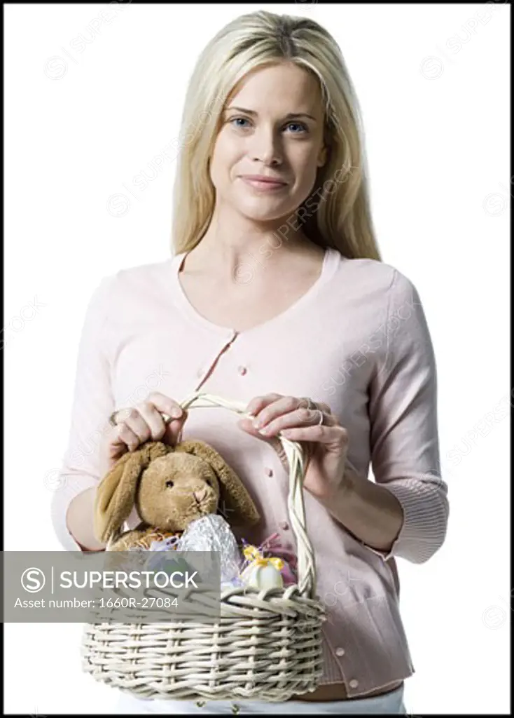 Portrait of a young woman holding a teddy bear in a wicker basket