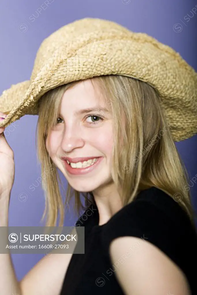 Portrait of a girl holding her hat
