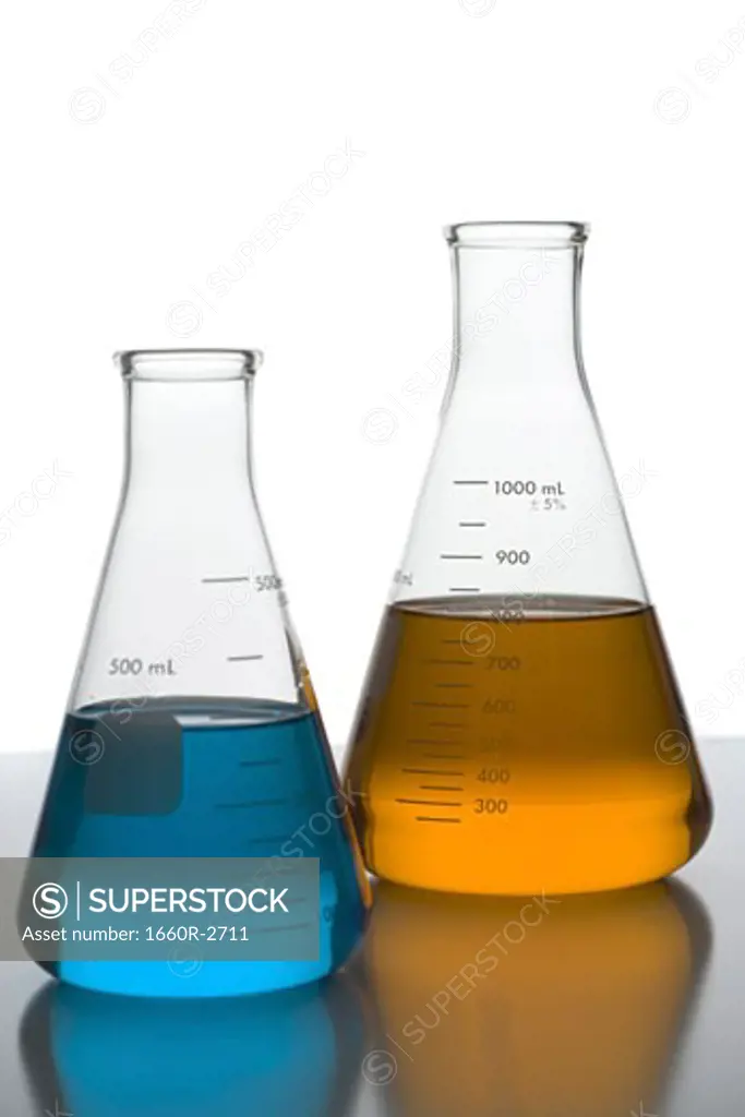 Close-up of beakers on a table in a laboratory with colored liquid