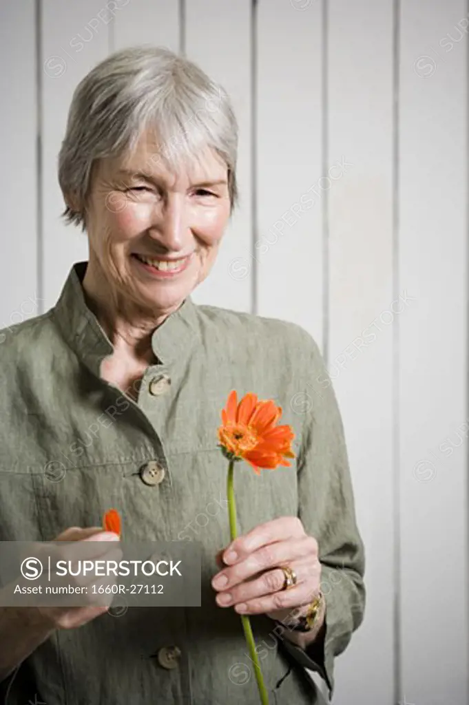 Portrait of an elderly woman holding a flower
