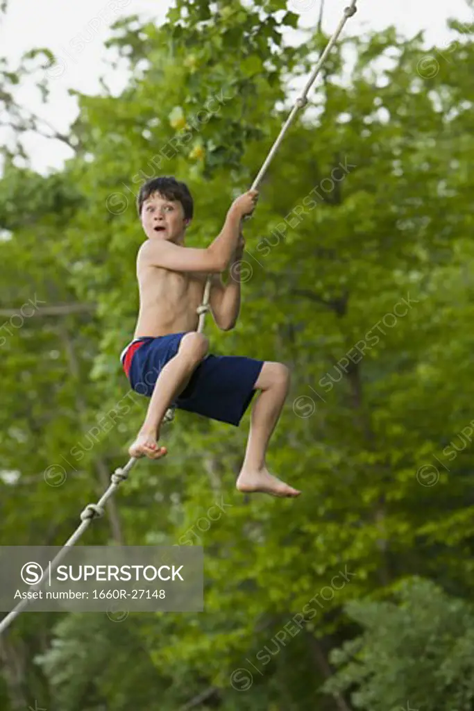Profile of a boy swinging on a rope