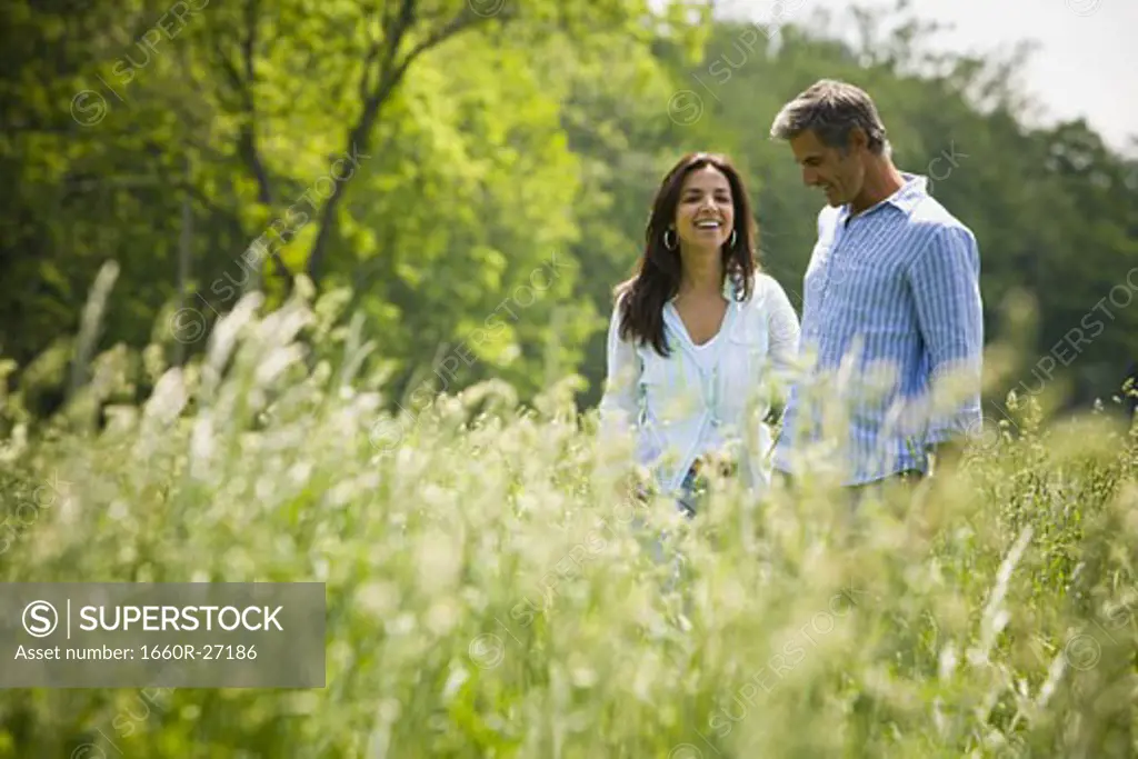 Profile of a man and a woman nuzzling in a field
