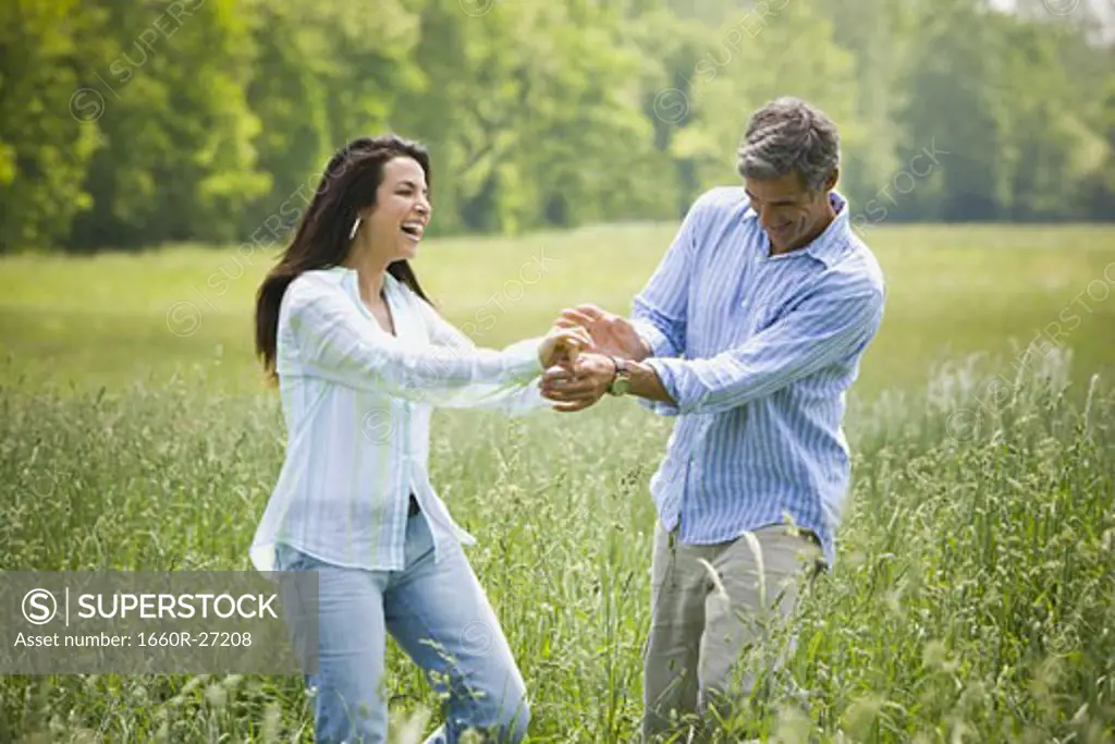 man and a woman holding hands in a field