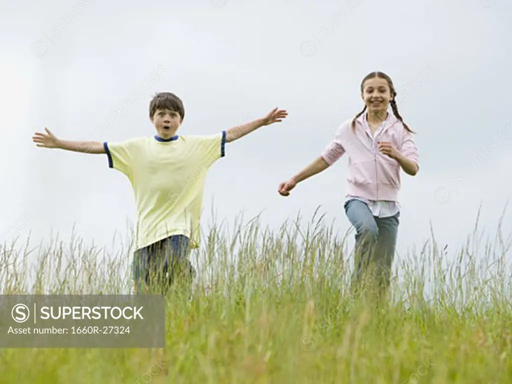 Boy and a girl running in a field
