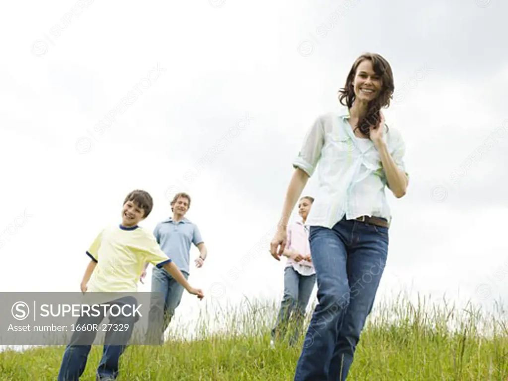Low angle view of a woman and a man with their son and daughter in a field