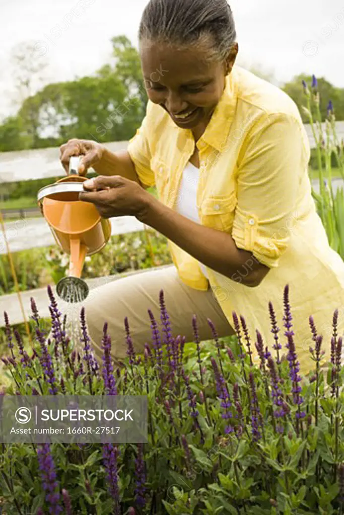 Close-up of a senior woman watering flowers