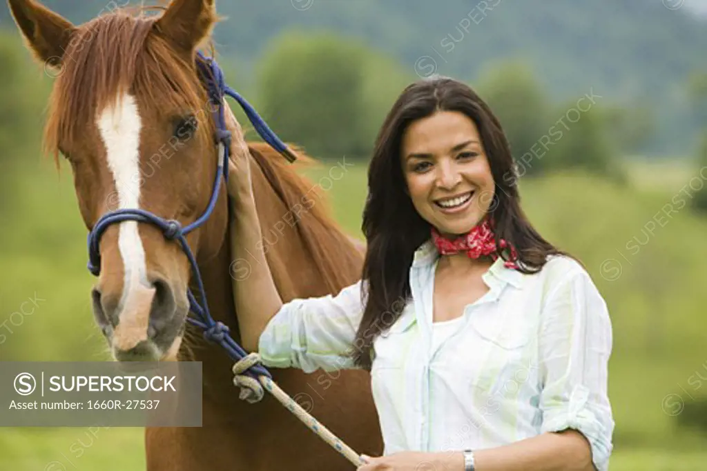 Portrait of a woman holding the reins of a horse