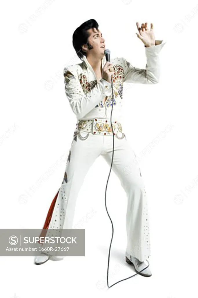 An Elvis impersonator singing into a microphone
