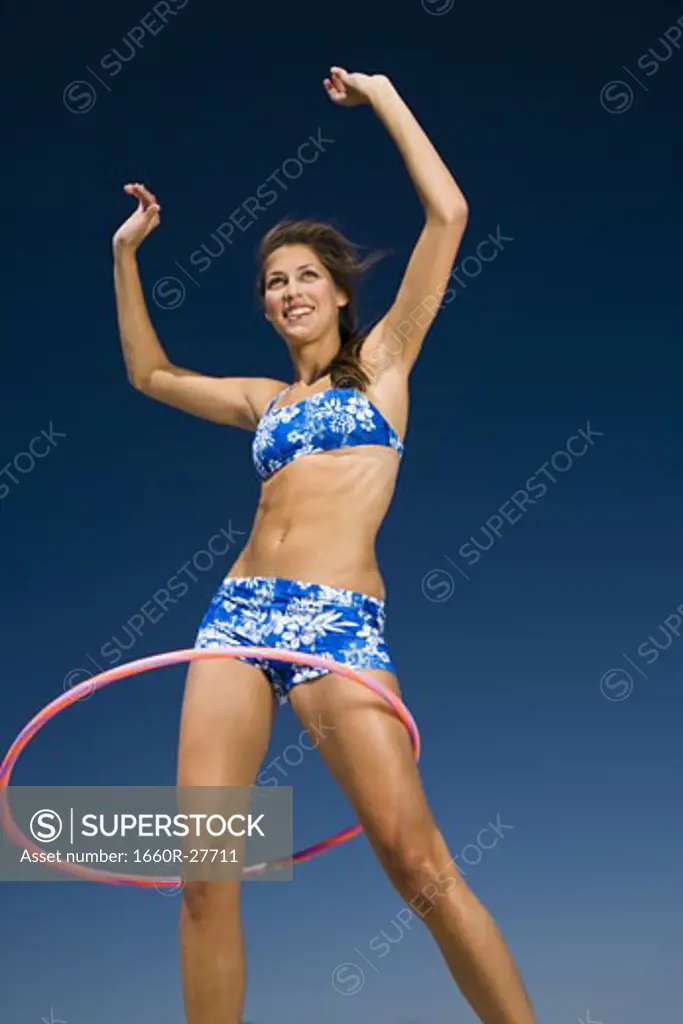 Young woman playing with a hula hoop