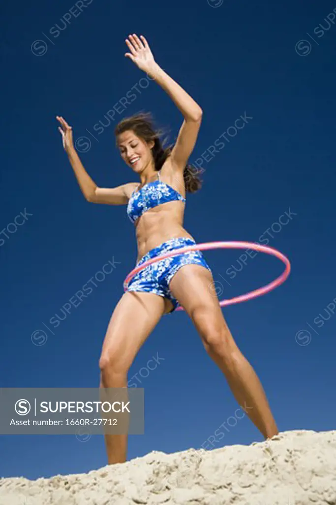 Young woman playing with a hula hoop