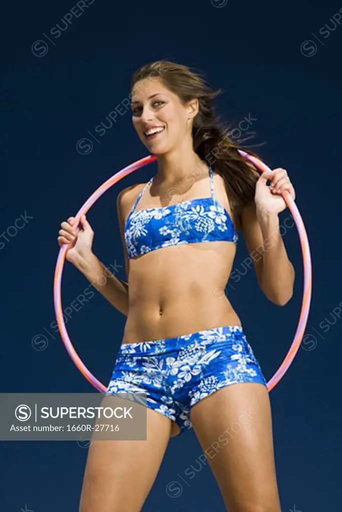 Portrait of a young woman holding a hula hoop and smiling