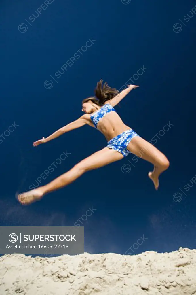 Low angle view of a young woman jumping
