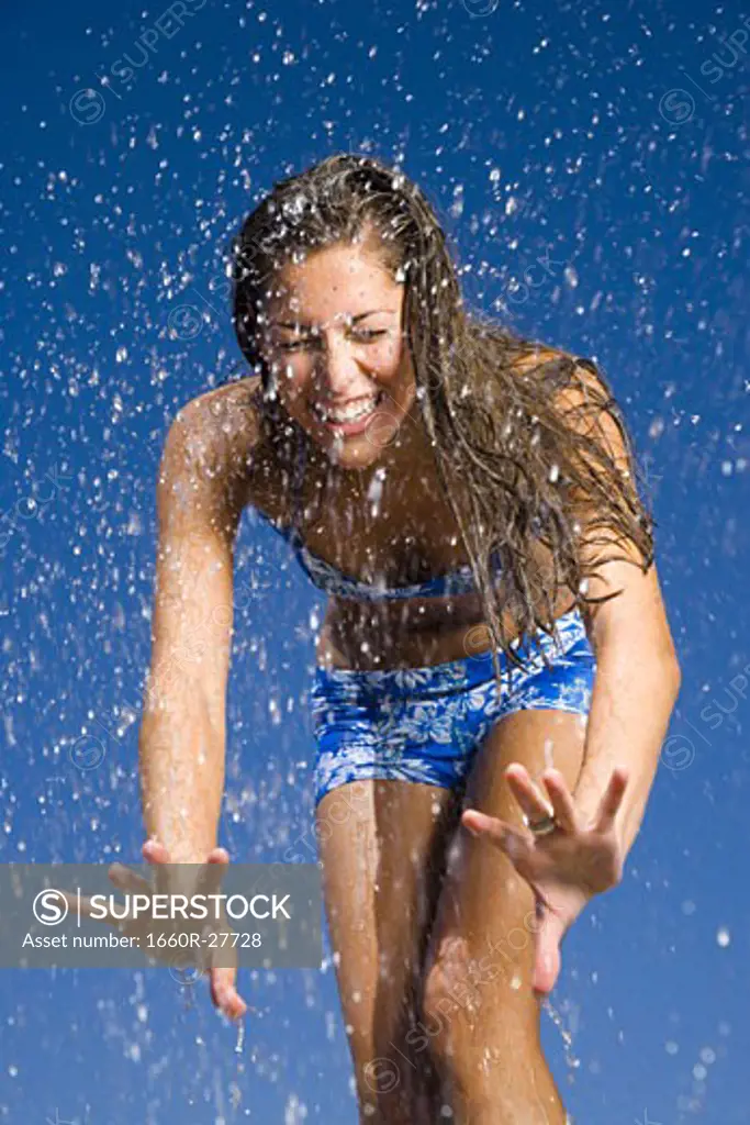 Close-up of a young woman getting sprayed with water