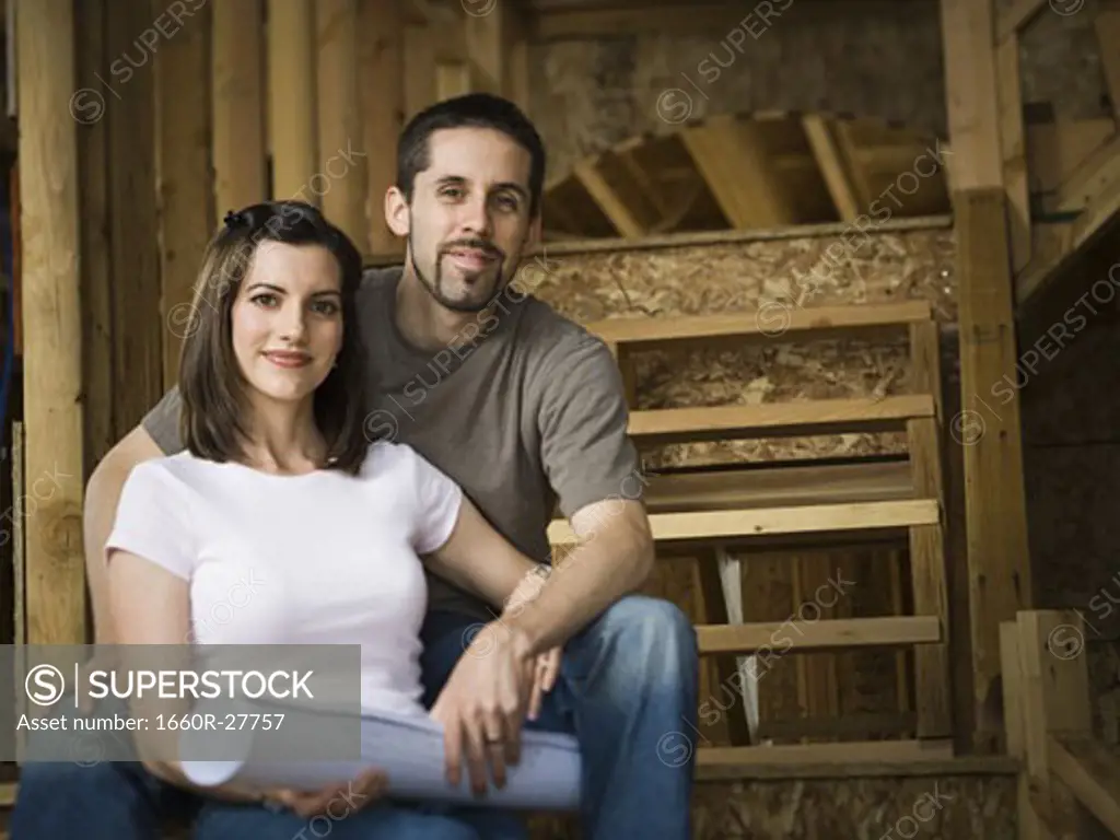Portrait of a young couple sitting on a staircase and smiling