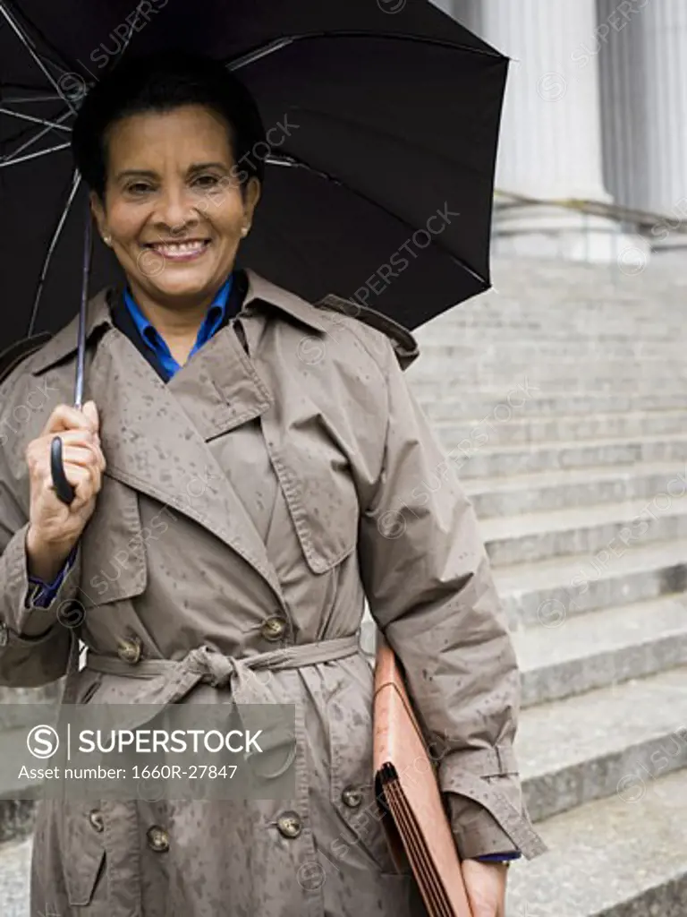 Low angle view of a woman holding an umbrella and smiling