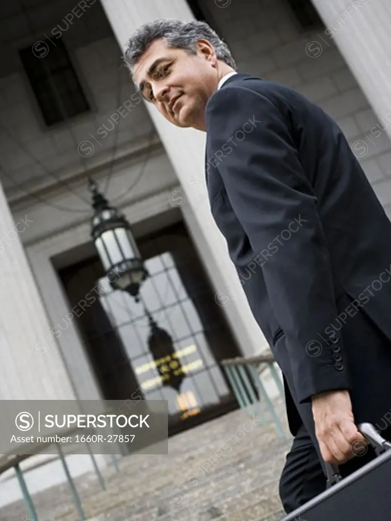 Low angle view of a man walking up the steps of a courthouse