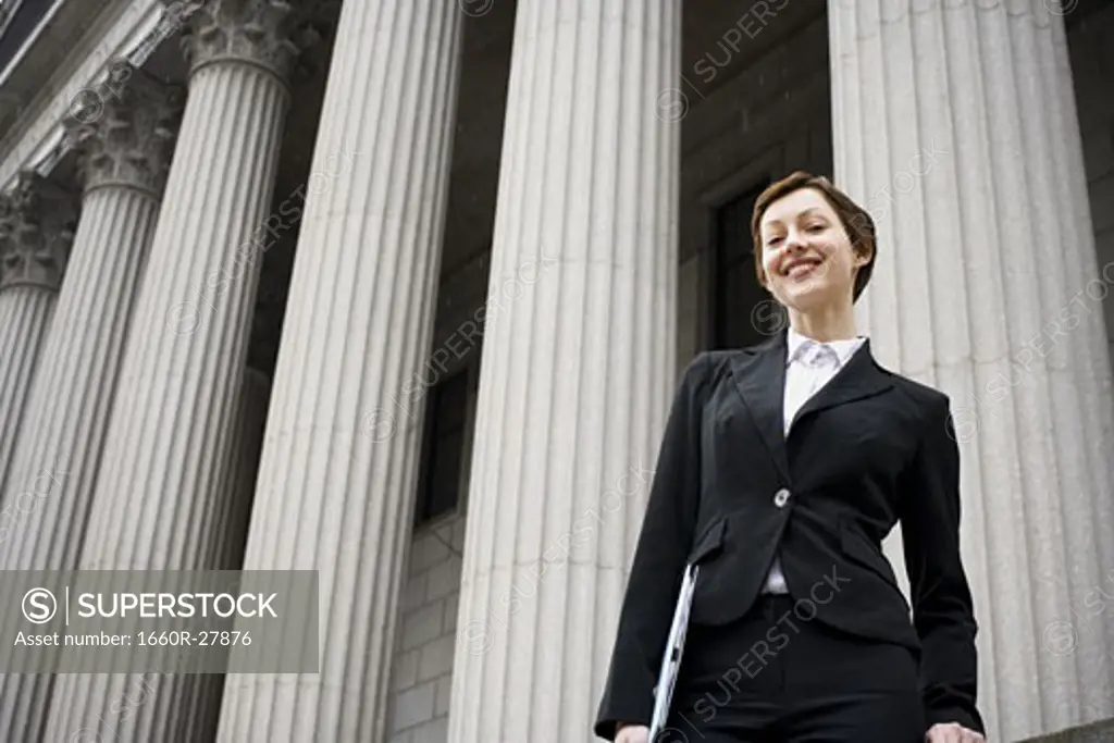 Low angle view of a female lawyer standing in front of a courthouse