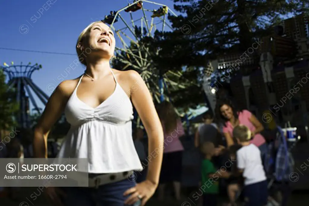 Low angle view of a young woman laughing in an amusement park