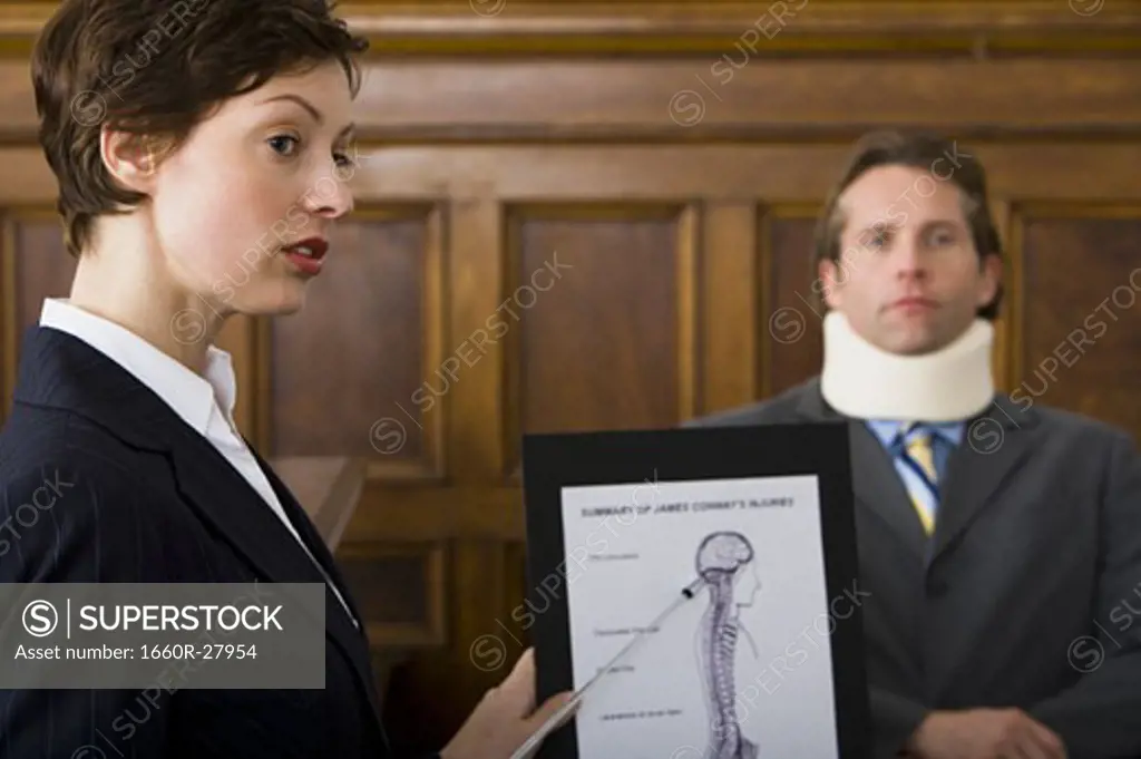 A female lawyer pointing at evidence in front of a victim in a courtroom