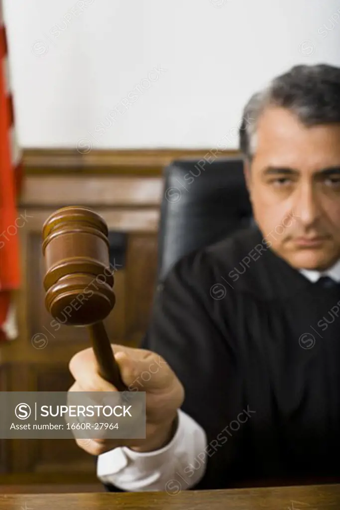 Close-up of a male judge hitting a gavel on the bench
