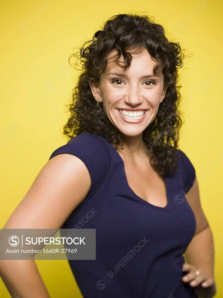 Portrait of a young woman smiling with her hands on her hips